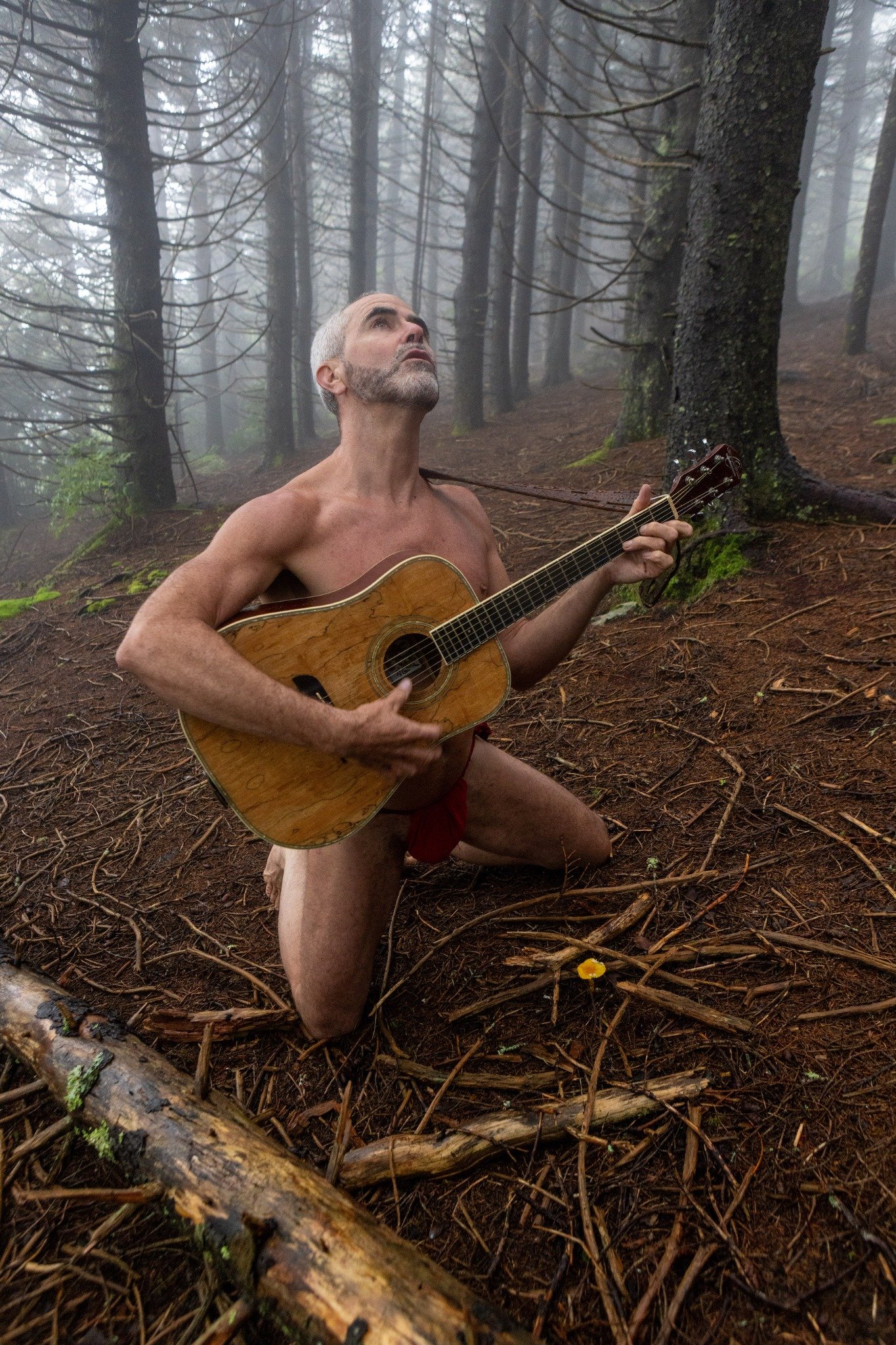 Brad Amberheart playing guitar in the woods
